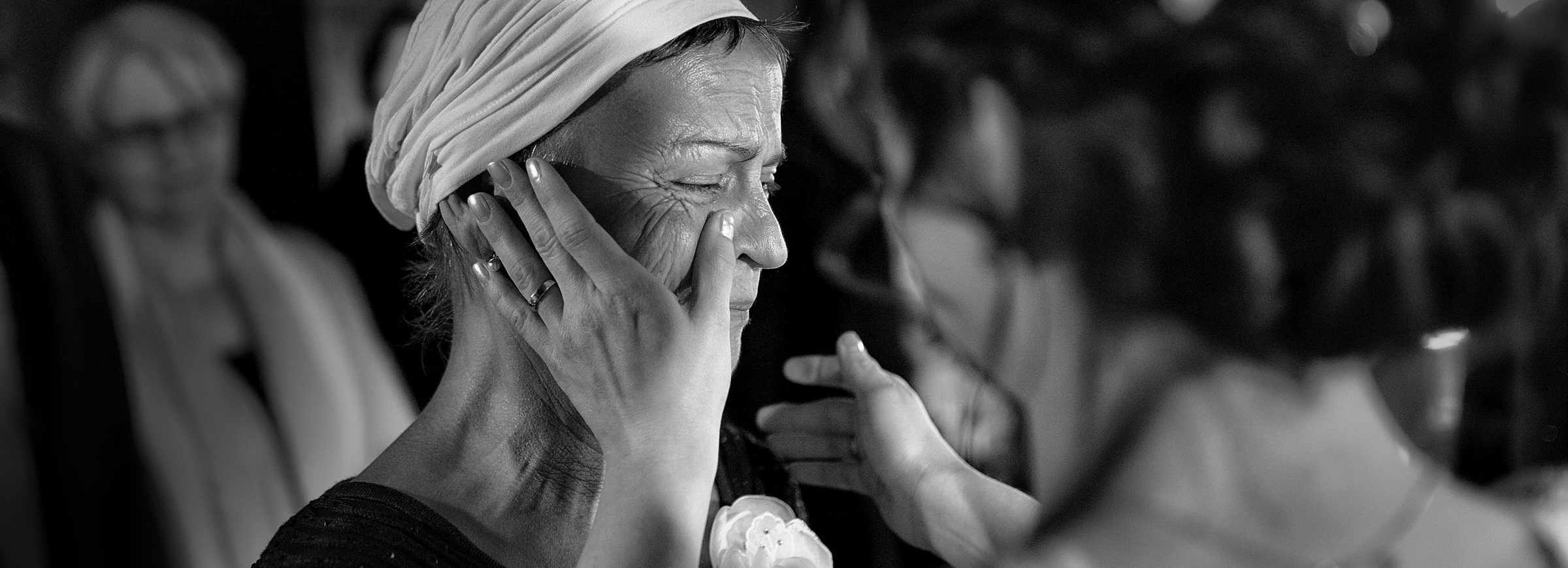 Eine Braut wischt die Träne von ihrer weinenden Mutter.