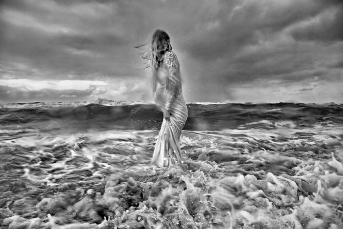 Braut steht voll nass und durchgefroren mitten im Meer auf Sylt