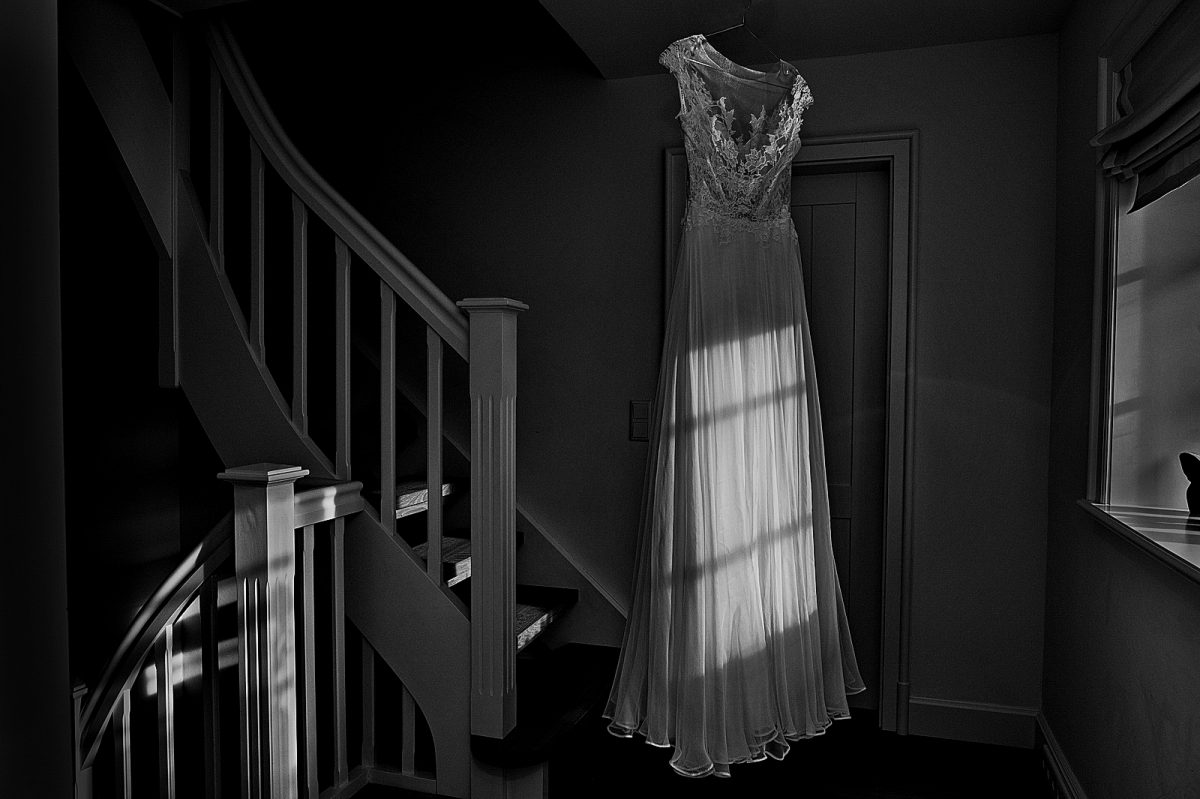 Hochzeitskleid hängt auf dem Bügel in Treppenhaus